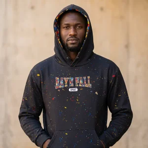 Man wearing the black Baye Fall hoodie with the hood up revealing the ndiakhass patchwork lining